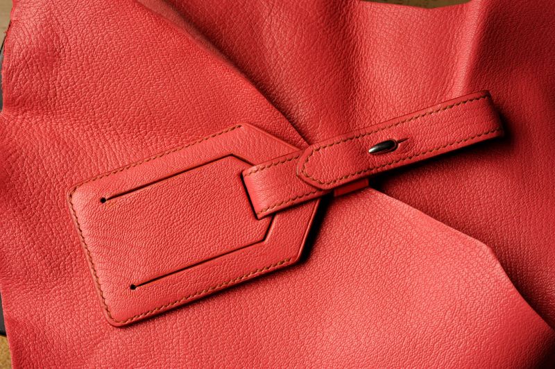 Cousu sellier sur une étiquette à bagages en cuir rose Ruadh sellier maroquinier Bretagne Rennes Cousu sellier sur une étiquette à bagages en cuir rose Ruadh sellier maroquinier Bretagne Rennes